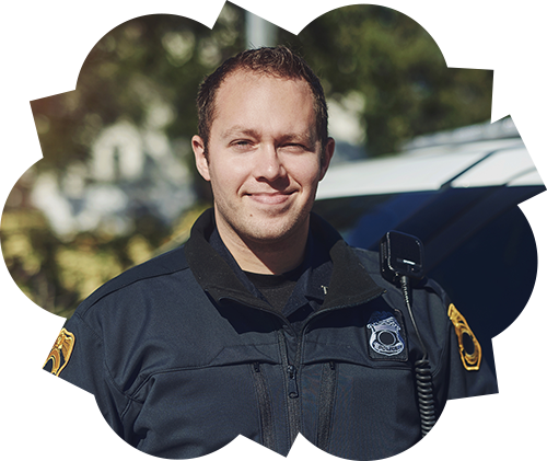 friendly officer facing camera in front of police car